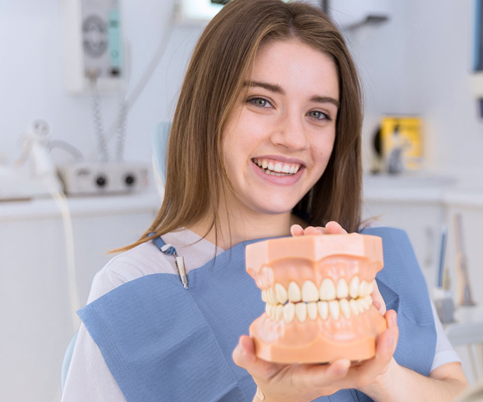 teenager holding a dental figure